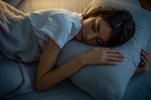 iStock Credit: bymuratdeniz Overhead view of a woman sleeping in a bed